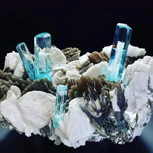 Aquamarine gem under daylight versus spotlight showing distinct color shifts