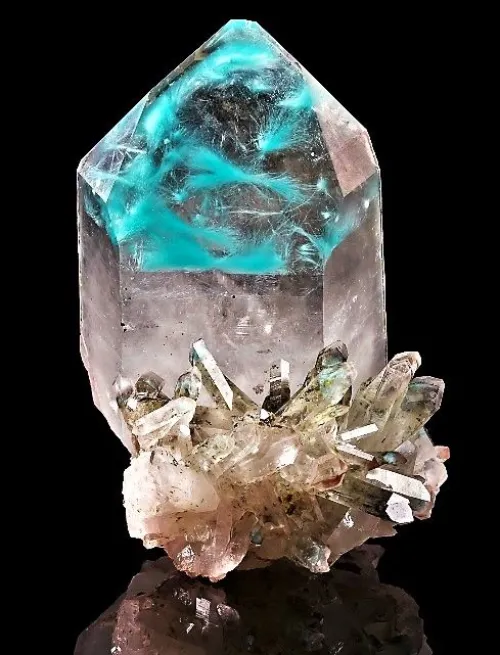 Geologist using portable analyzer on rock sample near drilling equipment